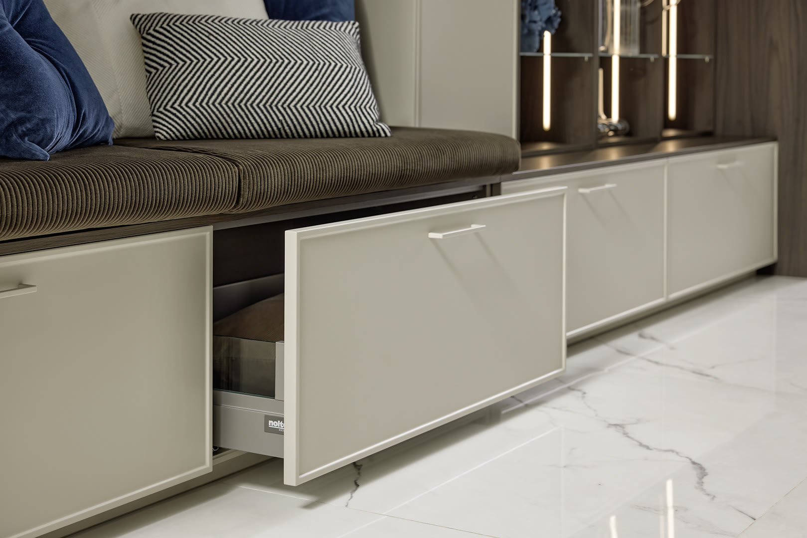 Greige framed drawer pulled clear of its runners, showing the drawer box and full-extension slides beneath a bench seat.