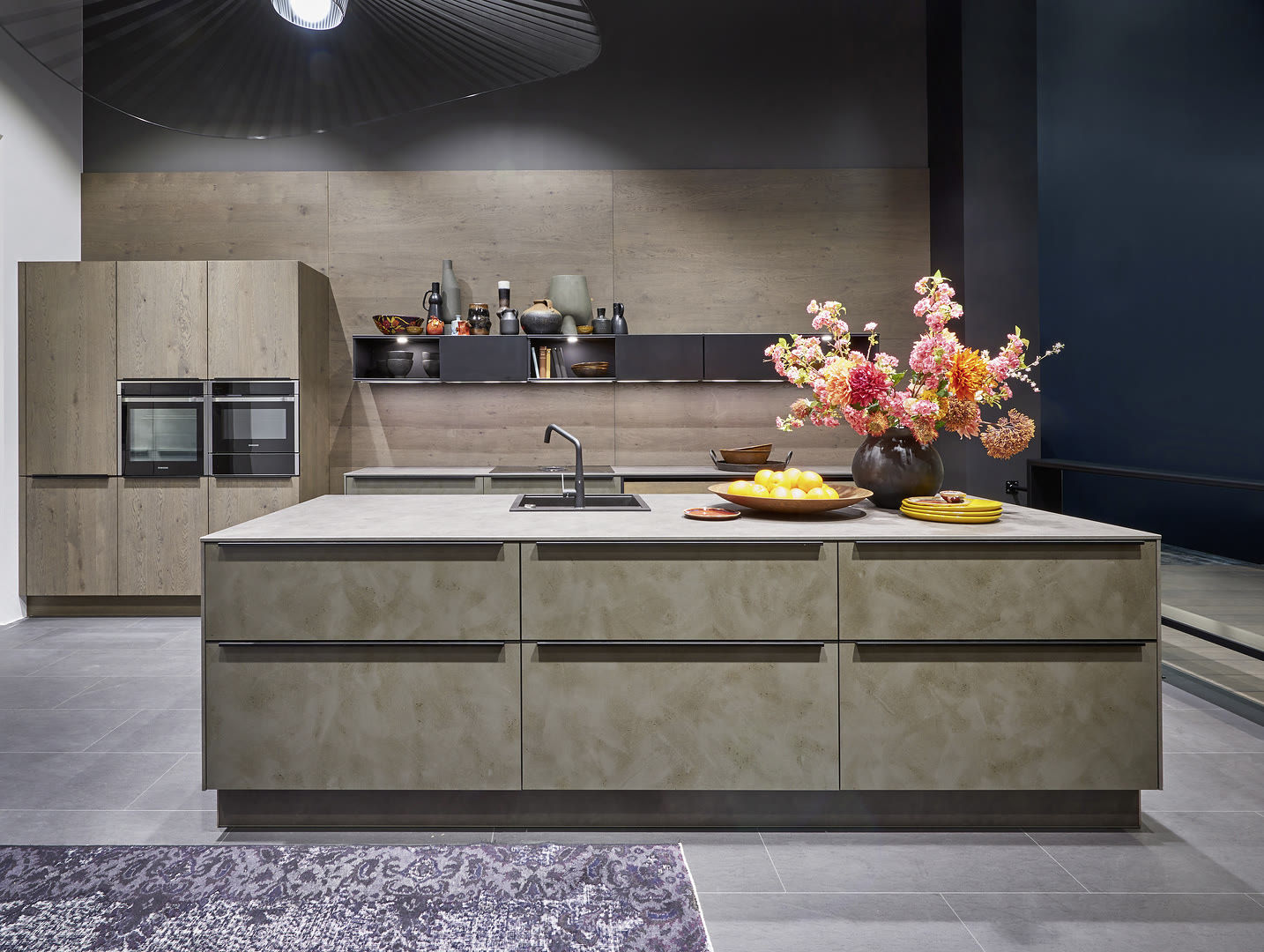 Finished kitchen with a large light wood veneer island, white countertop, and matching wood cabinetry