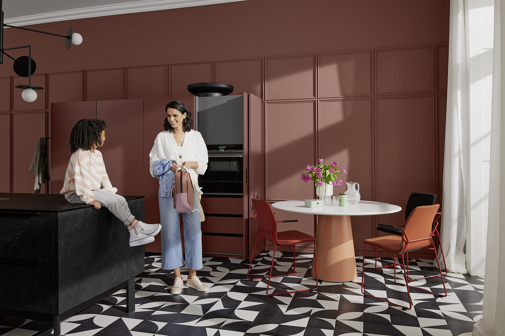 Kitchen with neoSLATE fronts in deep-black slate and Soft Lack in henna red.