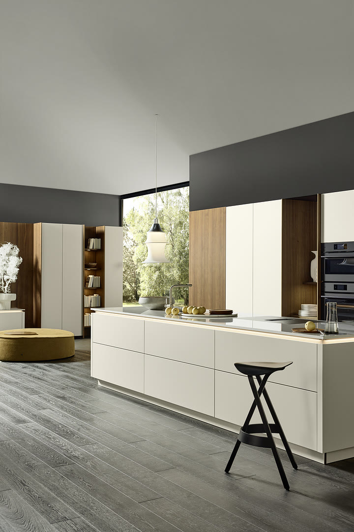 Modern kitchen with white handleless cabinets, a stone-topped island, and pendant lighting.