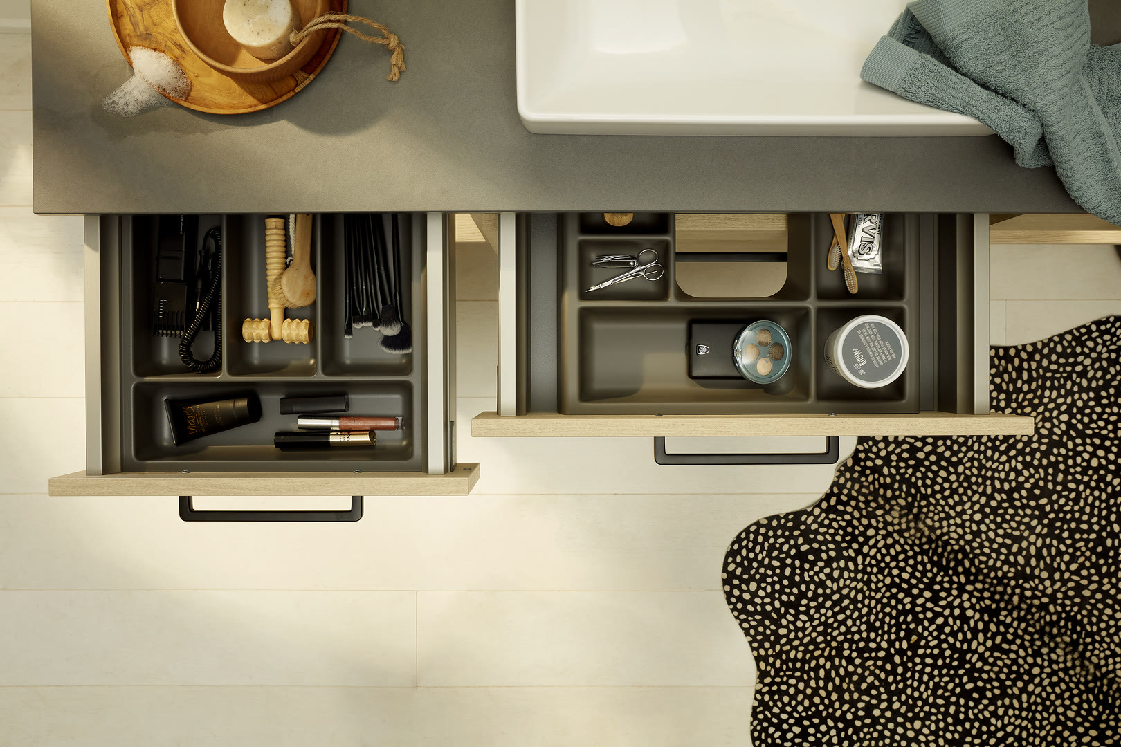 Overhead view of open kitchen drawers with gray interiors containing organized utensils, cookware, and kitchen tools